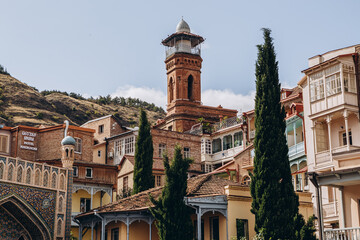 Obraz premium view of old stone houses with beautiful colored roofs in the center of the old town where tourists are walking