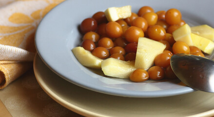Cherry plum and zucchini stewed fruit compote dessert on the plate on kitchen table, closeup, copy space, homemade seasonal desserts concept
