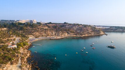 Fototapeta na wymiar Aerial bird's eye view of Konnos beach, Cavo Greco Protaras, Paralimni, Famagusta, Cyprus. Famous tourist attraction golden sandy bay with boats, yachts in the sea, sunbeds, water sports, from above.
