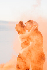 guy and a girl in black clothes hug and run on the white sand