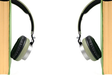 Headphones and a book on a white background. Listen to audiobooks online.