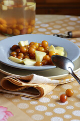 Cherry plum and zucchini stewed fruit compote dessert on the plate on kitchen table, closeup, copy space, homemade seasonal desserts concept