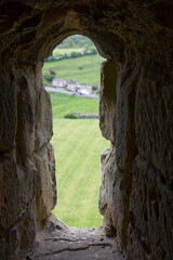 looking out a window in castle ruins with green grass in the background
