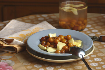 Cherry plum and zucchini stewed fruit compote dessert on the plate on kitchen table, closeup, copy space, homemade seasonal desserts concept