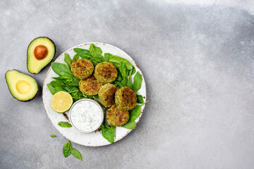 Veggie Falafel Patties With Yogurt Sauce. Healthy Vegetable Avocado Spinach Chickpea Fritters. Top view copy space on grey concrete backdrop