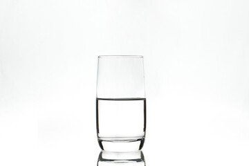 Half full glass on white background. Isolated. Backlight.