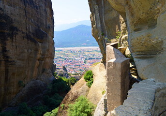 View of the city between the rocks in the mountains in sunny summer weather