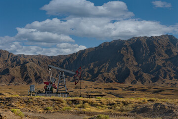 Tajikistan. Mechanical drive rod pump (rocker) daily pumps oil from a well in the Pamir mountains near the city of Isfara