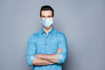 Portrait of his he nice attractive virile masculine cheery healthy content guy wearing casual shirt medical gauze mask folded arms illness disease prevention isolated over grey pastel color background