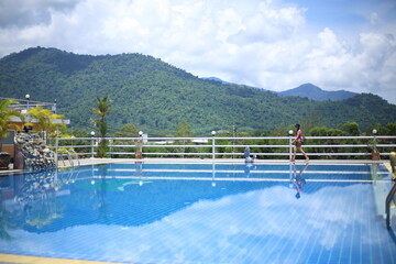 Woman standing at the pool area with mountain views