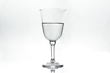Half full wineglass on white background. Isolated. Backlight.