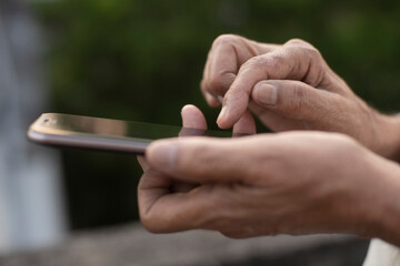 Man operating cellphone holding with his hand.