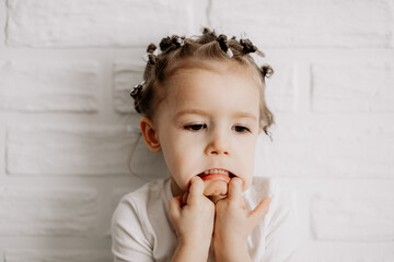 Portrait of a girl with bright sincere baby emotions. Little curly girl posing for a photo