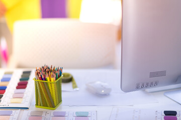Designer sewing tools, fabric thread, colored pencils on the desk