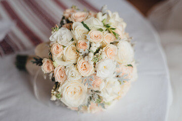 Close up of pastel wedding bouquet  of rose and peon lying on the table