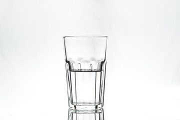 Half full glass on white background. Isolated. Backlight.