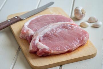 Raw pork meat on wooden board .