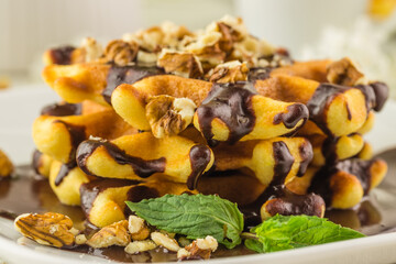 Breakfast in cafe - Belgian waffles with sauce and a cup of tea on a wooden table in room