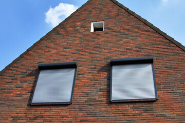 Windows with rolling shutters on the brick wall. Houce protection.