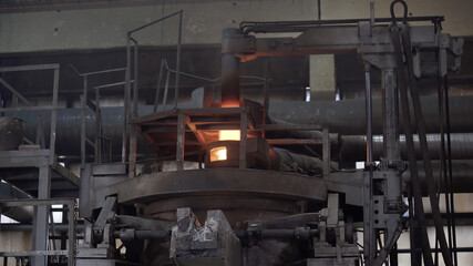 Molten metal in modern induction furnace. Casting liquid metal. Molten metal melted in furnace at metallurgical plant. Iron and Steel Works. Converter plant. Smelting of metal.