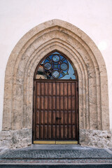 Fototapeta na wymiar Entrance oak doors of Church. Masonry walls and mosaic window
