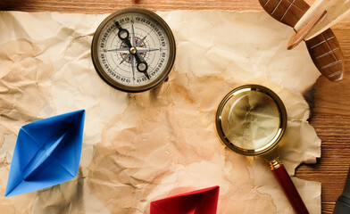 Map, compass and magnifier on the table.