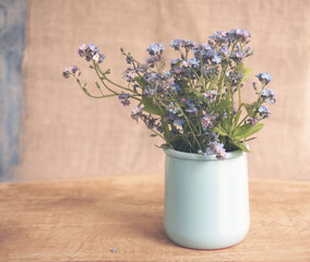 A gentle bouquet of field flowers in a blue ceramic vase.   Soft focus, rendered photo              