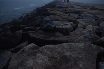large breakwater rocks in the fog