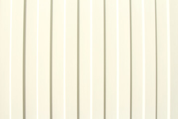 Obraz premium Photo of a white metal profile with vertical parallel lines on the fence.