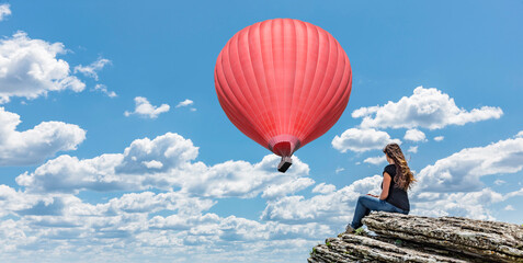 Fototapeta na wymiar Frau auf einer Klippe mit Heissluftballon