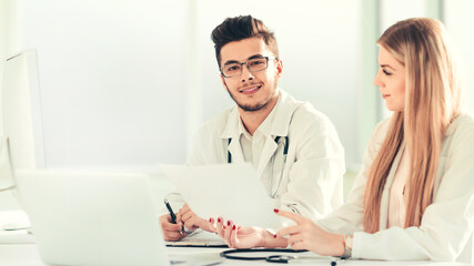 Fototapeta premium doctors colleagues talking sitting at a table in the office