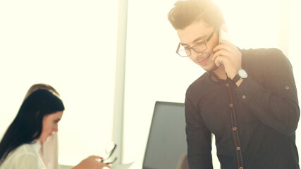 young businessman talking on his smartphone in the office