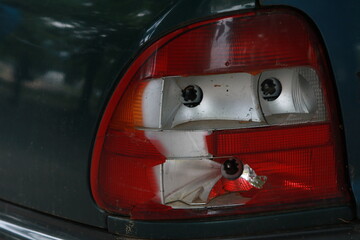 Abandoned car with broken windshield and side windows, flat tires and broken headlights