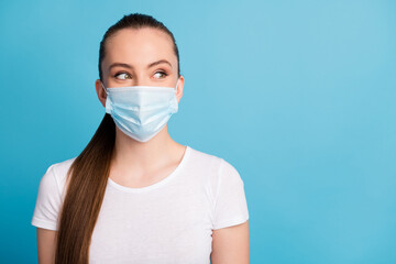 Closeup photo of pretty young lady look side empty space keep social distance not contacting people funny expression wear protect face medical mask white t-shirt isolated blue color background
