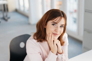 Young woman looking up with a thoughtful smile