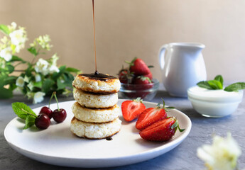 cheese pancakes or sirniki, syrniki poured with fruit and chocolate, delicious breakfast, horizontal orientation
