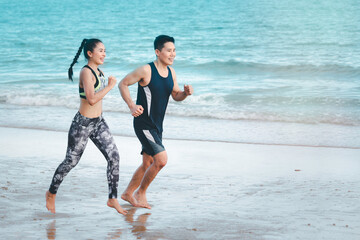 Young runner jogging outdoor on summer tropical island beach with blue sea, doing exercise outdoor, sport guy jogger athlete doing and training workout outdoor