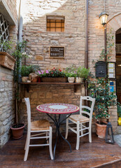 Fototapeta na wymiar street furniture, romantic corner, chairs with table and lamp in a old italian city,street furniture for a party, photo from bottom, natural light