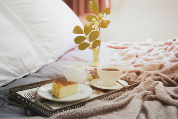 Breakfast in bed slice of Cheesescake with coffee cup flower in a tray.