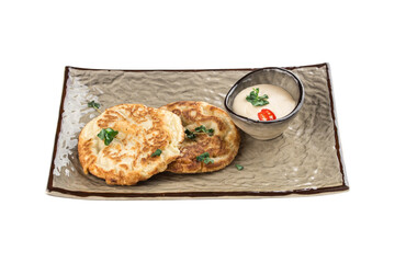 Pancakes with sour cream and chili pepper on grey plate isolated on white background