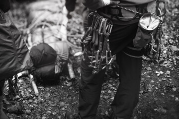 Climbing equipment on the climber's harness on the background of the body of the victim on a stretcher. The rescue work. Close-up, black and white.