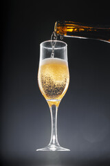 Champagne pouring into glass on black background