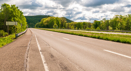 A highway through the woods in Warren County, Pennsylvania, USA on a sunny spring day