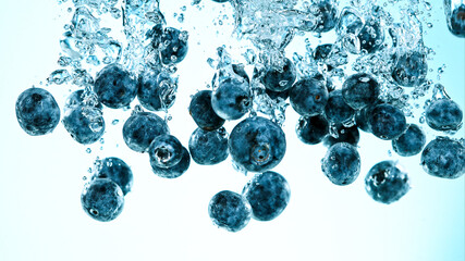 Freeze Motion Shot of Fresh Blueberries Falling Into Water Isolated on White Background.