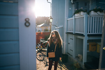 a girl in sunglasses walks around the old city in autumn on a Sunny day