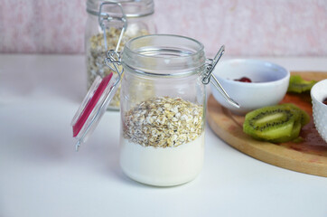 Healthy breakfast overnight oats with fresh berries in a glass jar with dried fruits, apple and nuts, walnuts, almonds. with yogurt, cottage cheese, pudding. diet, keto diet