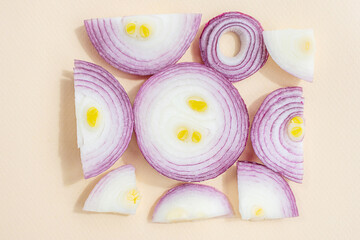 Red sliced onions folded into a square shape on a light pastel background. The concept of healthy vegetables. Textural food background.