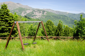 Obraz na płótnie Canvas Wooden swing in a mountain park