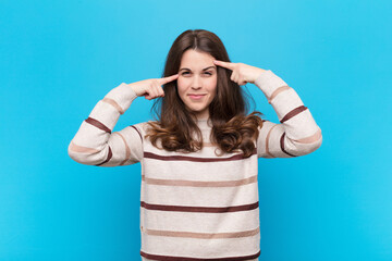 young pretty woman with a serious and concentrated look, brainstorming and thinking about a...