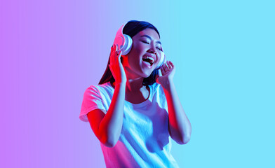 Favorite music online. Girl in modern headphones sings with eyes closed